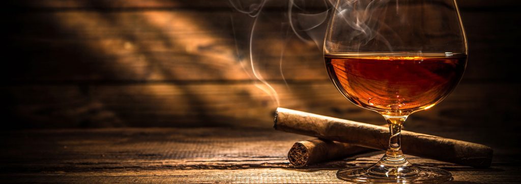 cigars burning and glass of whiskey