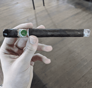 Hand holding Montesino No. 1 Maduro lightly ashed at the end