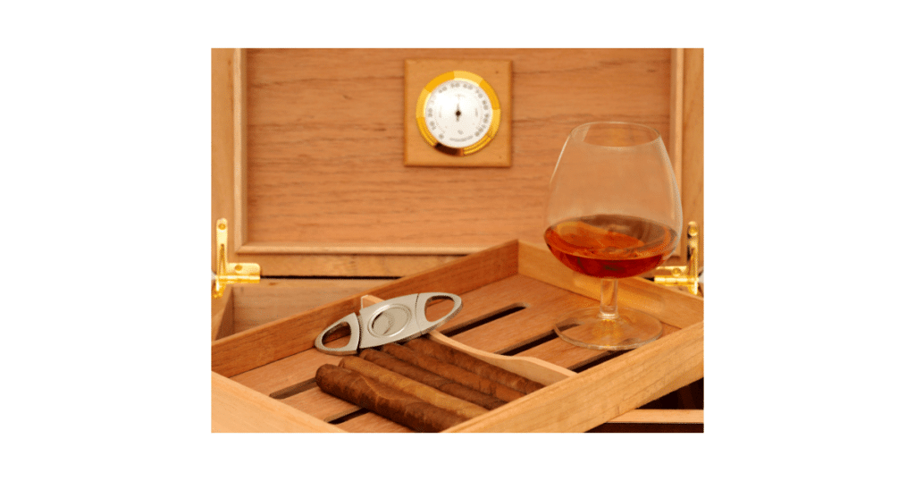 Open Cigar Humidor with Cigar Cutter and Glass of Whiskey