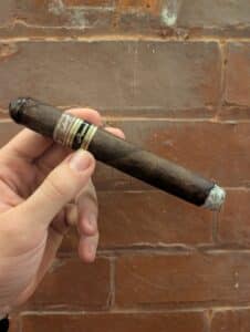 Tatuaje Cojonú infront of brick wall